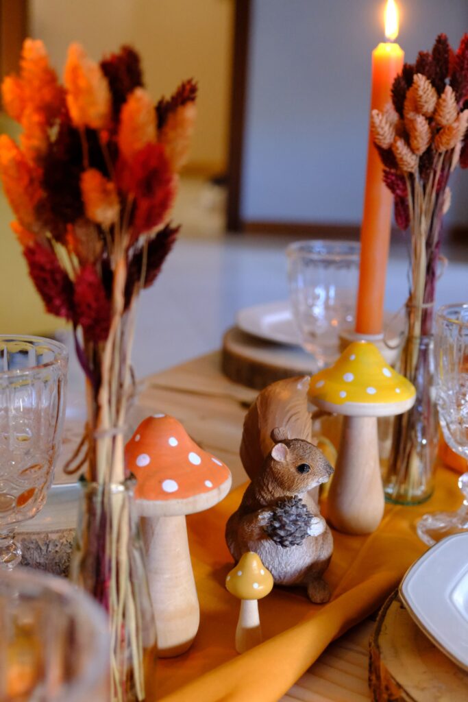 picnic autunnale con statuina a forma di scoiattolo e funghi di legno